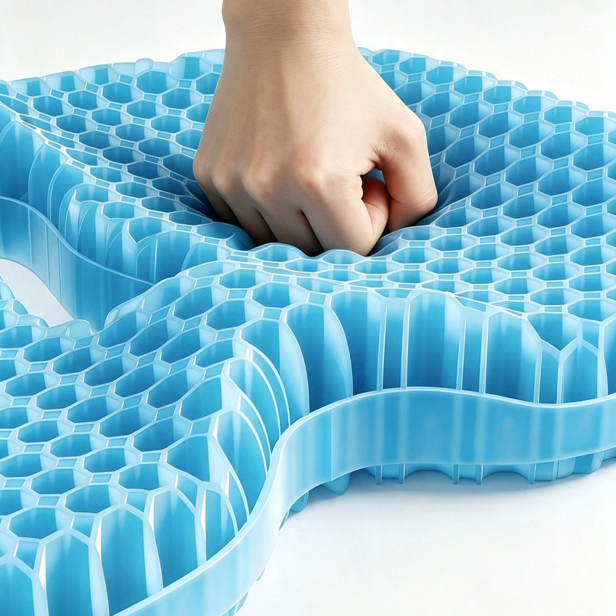 A light blue honeycomb TPE seat cushion being pressed down by a hand, shown on a clean white background.