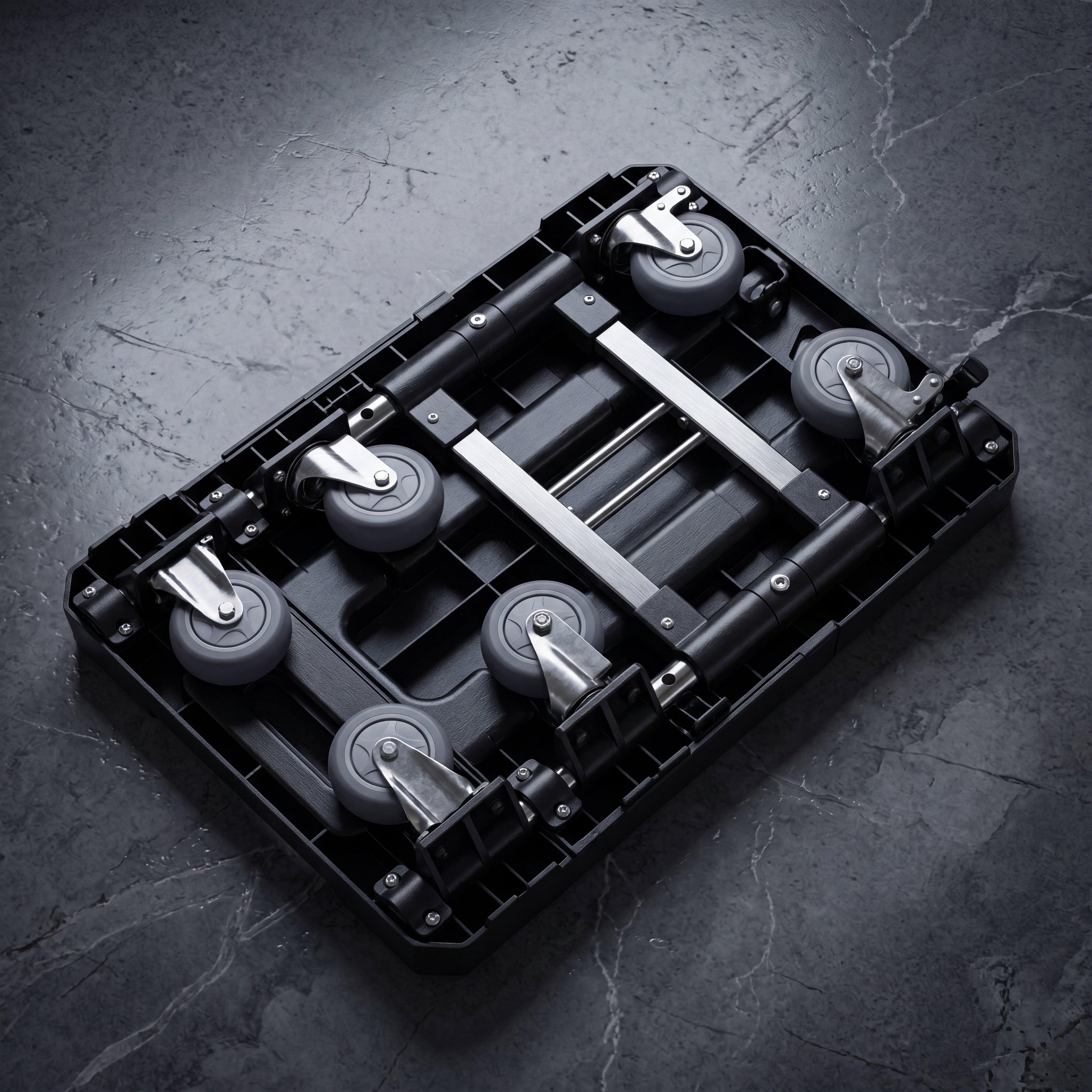 Black plastic component with wheels on a dark gray surface